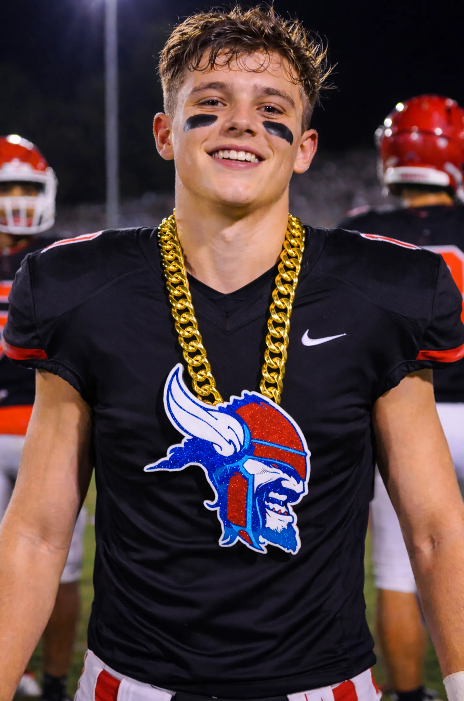 Football player wearing a blue logo pendant.
