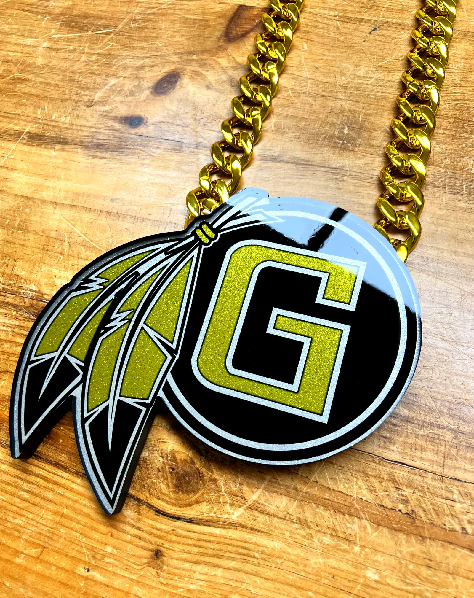 Close-up detail of football G logo feather pendant.