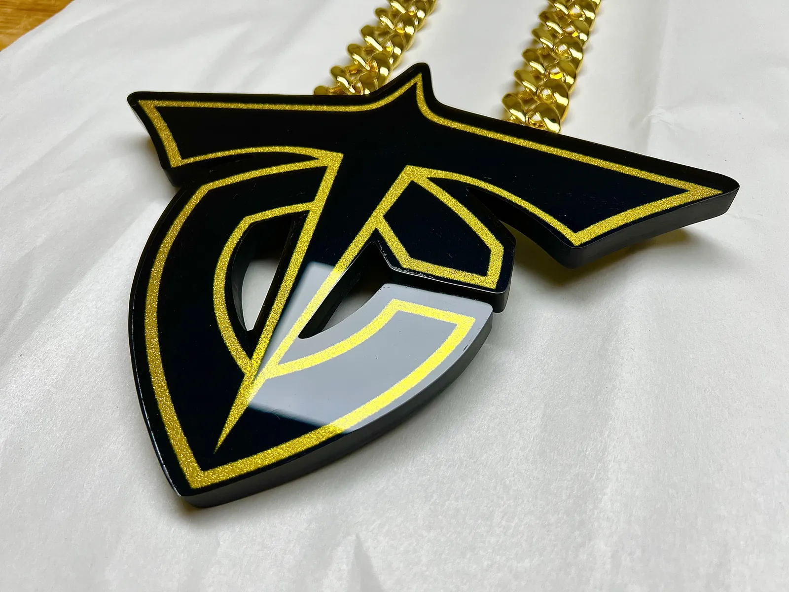 Stylized TC lettermark pendant design.