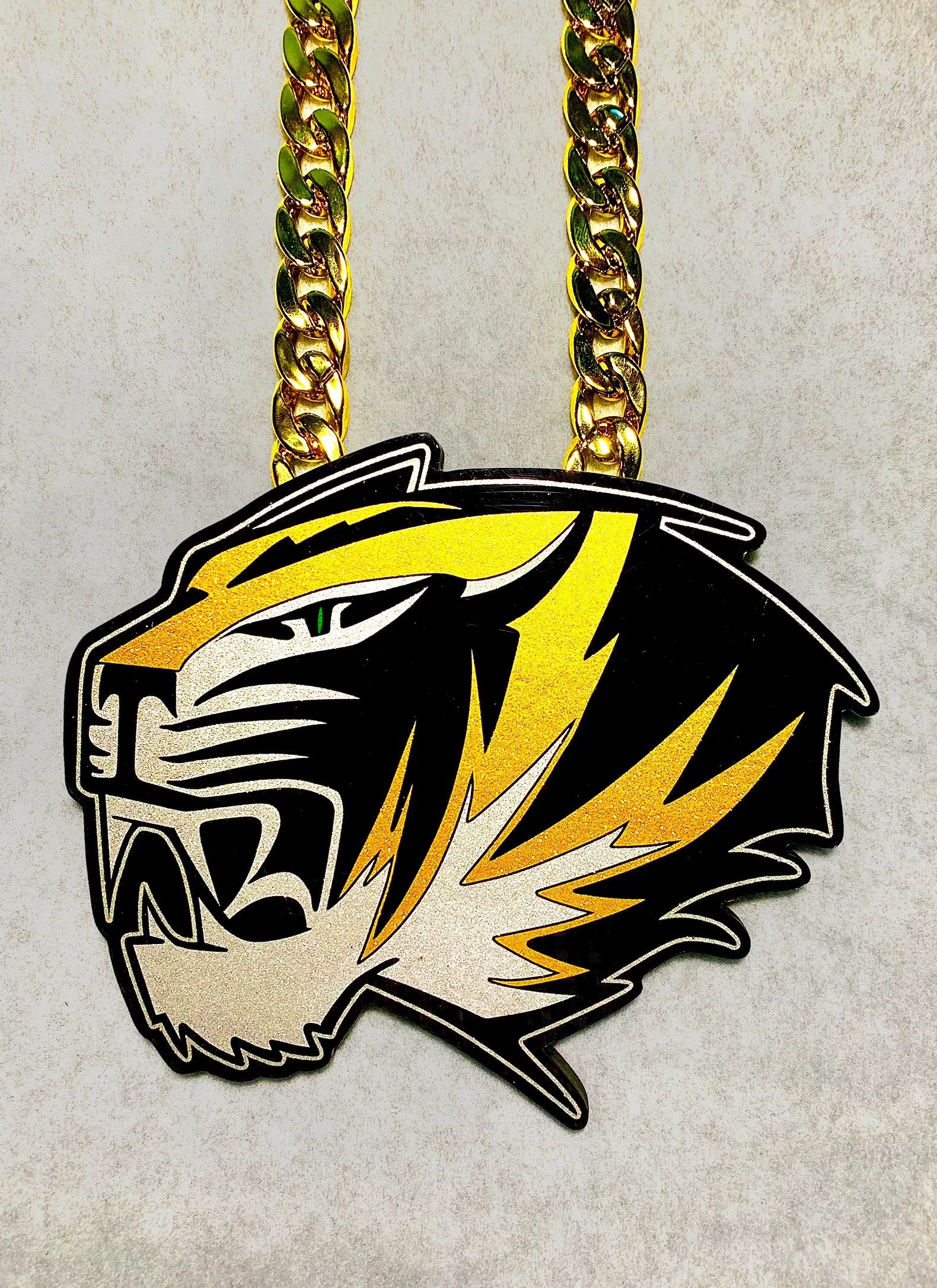 Tiger head profile pendant with bold mascot look.